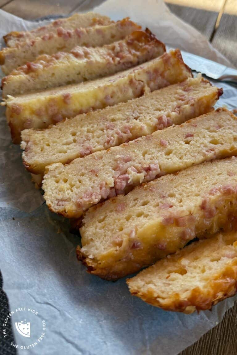 Golden gluten-free cheese and bacon bread loaf on parchment paper, ready to serve