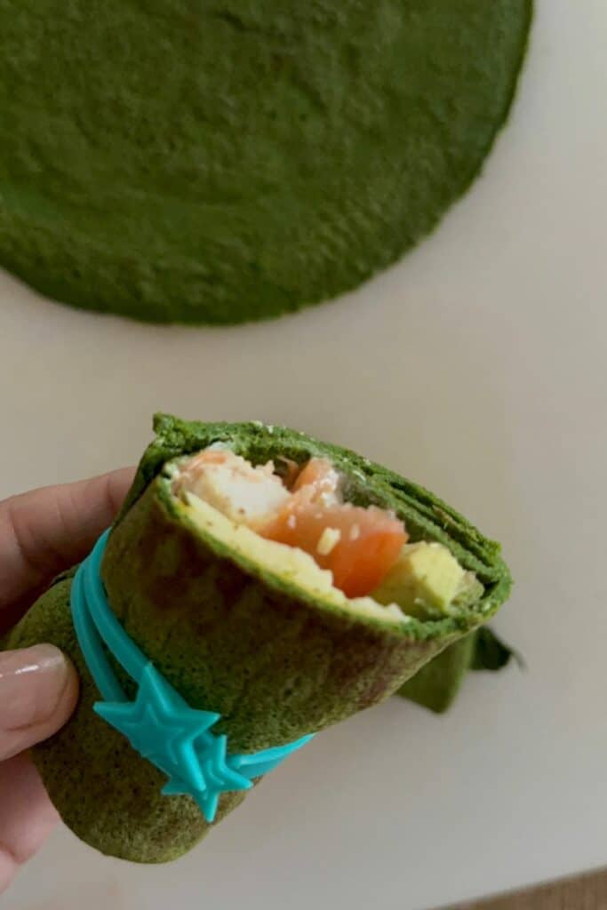 Healthy gluten-free spinach wraps filled with veggies and rolled up