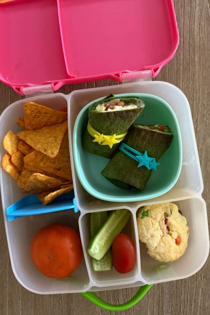 Spinach wraps filled with salad ingredients and rolled up for lunchboxes