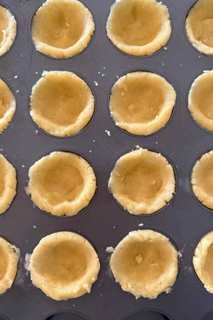 press the dough up the sides of each cup to create a tart shell shape.