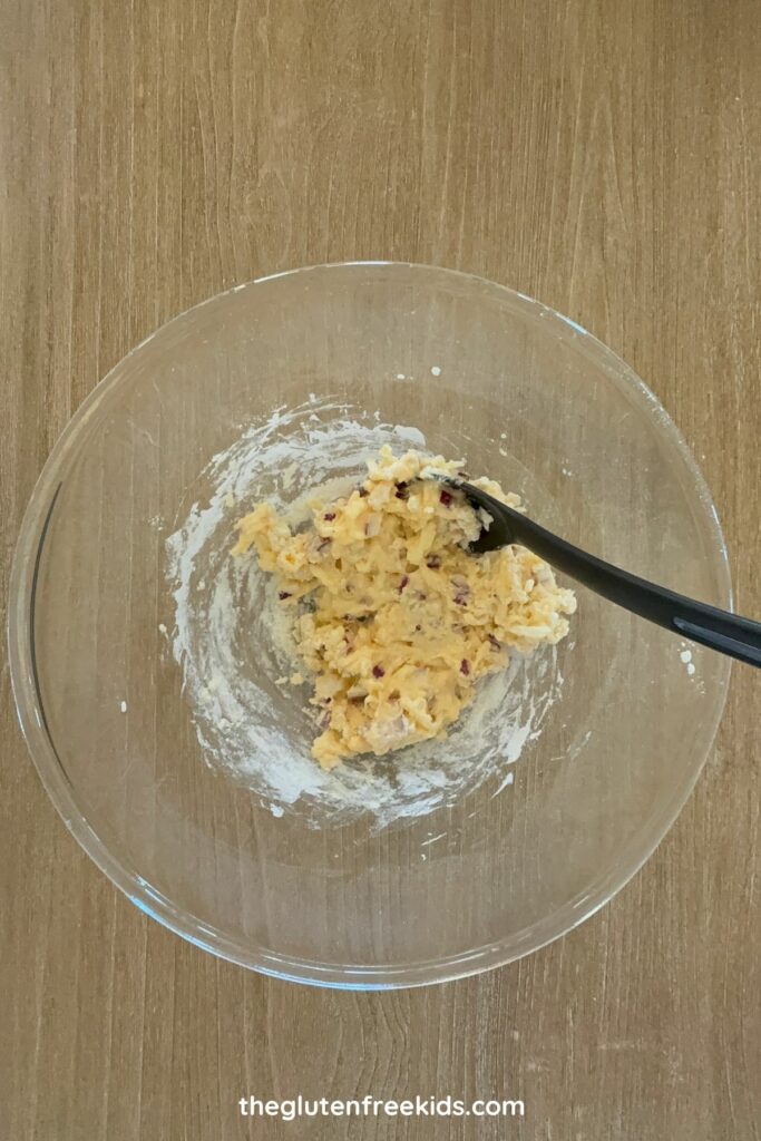 In a large bowl, whisk eggs. Add flour, baking powder, garlic powder, pepper, onion, and cheese.