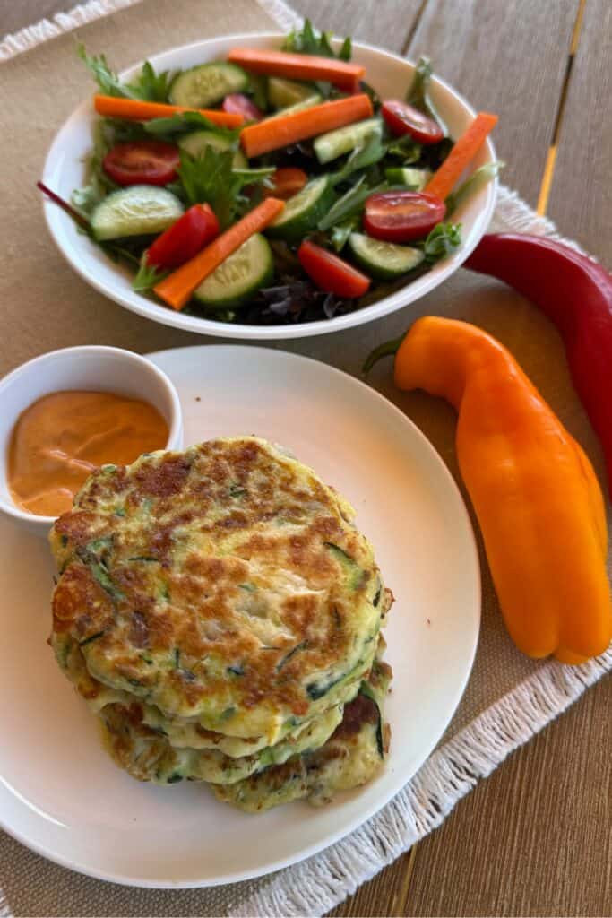 Stack of gluten free zucchini fritters with salad