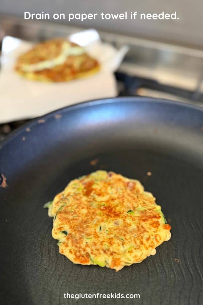 drain cooked zucchini fritters on paper towel